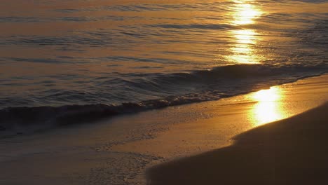 waves on sandy shore on calm morning at sunrise, mediterranean, spain