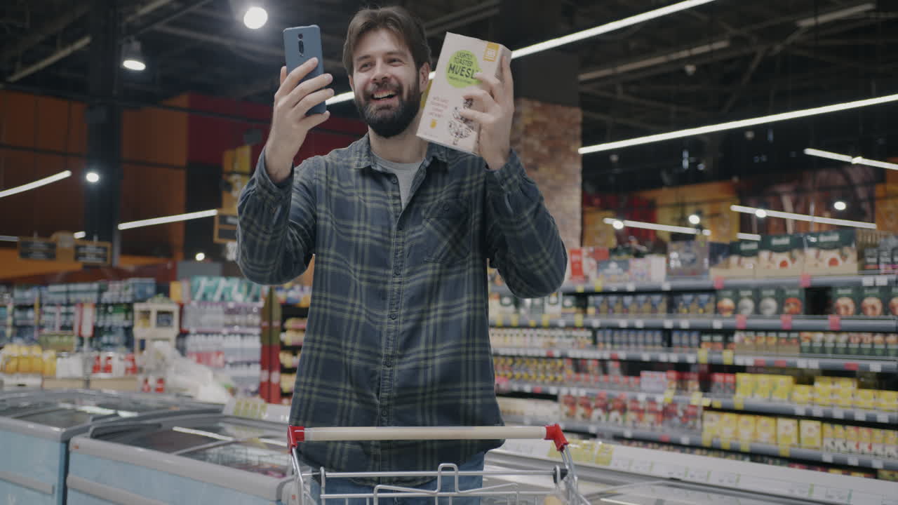 Man Shopping for Muesli and Checking Product Online in Grocery Store