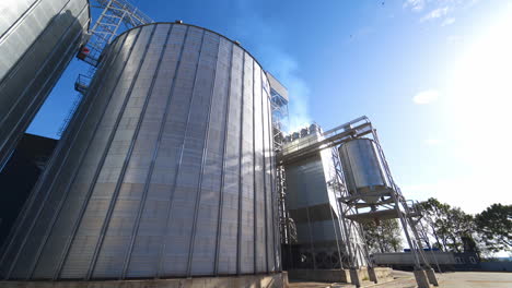 modern grain elevators at bright sunny day. large granary under blue sky. industrial manufacturing in the open air.