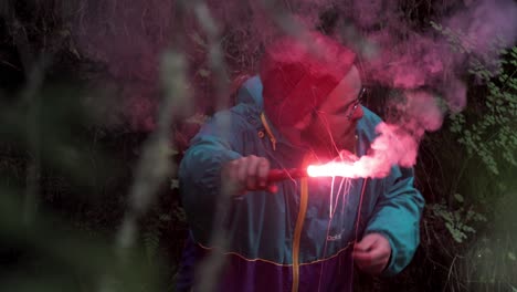 hombre con una chispa roja en el bosque por la noche