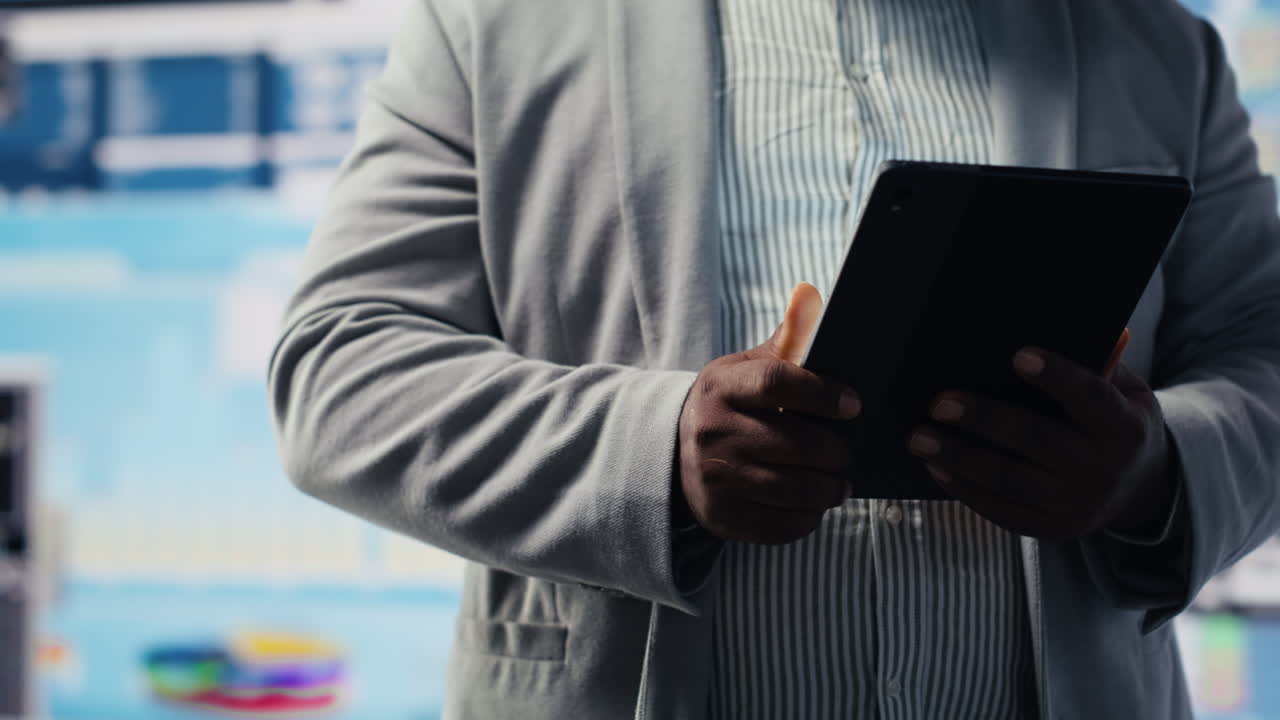 Black male entrepreneur reviews financial graphs and KPI models