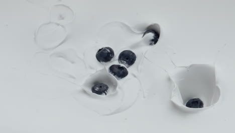 ripe blueberry falling yogurt in super slow motion close up. natural breakfast