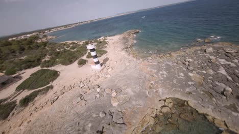 Fpv-Drone-Tiro-Giratorio-Sobre-Costas-Rocosas-Junto-Al-Faro-De-Punta-Plana-En-Faro-De-S&#39;estalella,-Mallorca,-Islas-Baleares,-España-Durante-El-Día