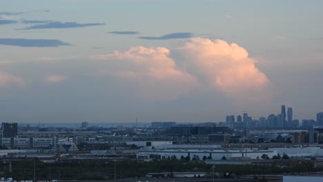 Silhouettes-of-Toronto-city-skyscrapers-in-Canada,-panorama-of-the-rising-city-in-the-early-morning-with-wandering-big-clouds---hyperlapse-static-shot
