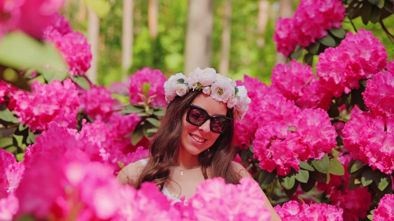 Slow motion close up enchanted european woman smiling in vibrant floral paradise