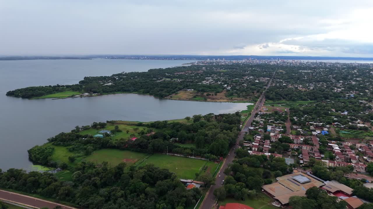Inquadratura aerea cinematografica che cattura la disposizione urbana di Posadas, Argentina. Il drone vola alto sopra Avenue Centenario, circondato da parchi verdi e abitazioni