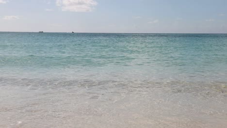 beautiful shore and gentle waves of seven mile beach in grand cayman on sunny summer afternoon