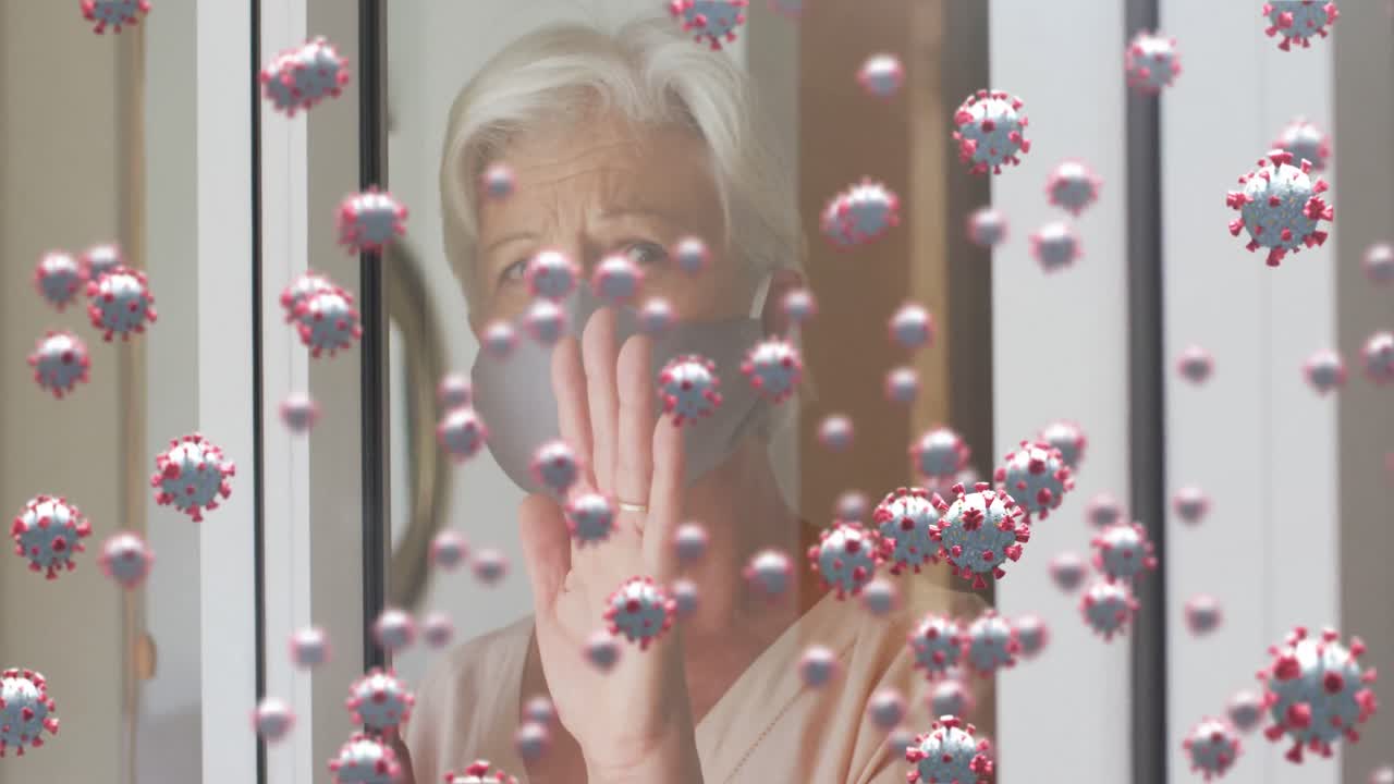 창문  ⁇ 에 마스크를 쓴 고령 여성 위의 코로나 19 세포의 애니메이션