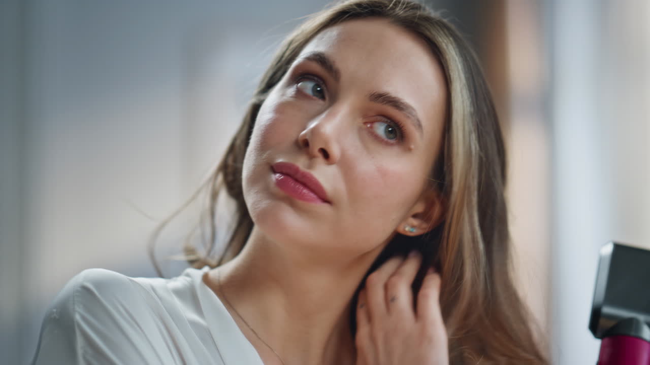 Beauty portrait of a woman using a hair dryer