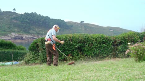 Hombre-Mayor-Con-Máscara-Protectora-Cortando-Césped-Con-Cortacésped