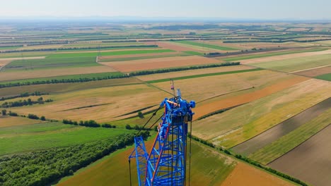 Blue-Tower-Crane-At-The-Erection-Site-Of-Wind-Turbines-At-Agricultural-Field-In-Austria