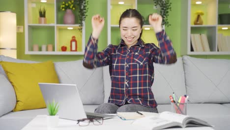 asian young woman working on laptop is experiencing joy.