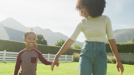 video of happy african american mother and daughter spending time together in the garden