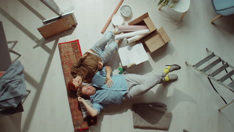 couple lying on floor and discussing home renovation ideas