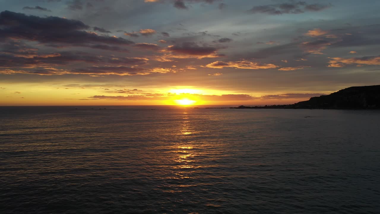 Slow drone flyover water towards beautiful sunrise in Kaikoura