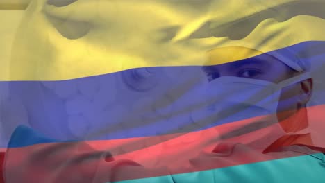 Animation-of-waving-colombia-flag-against-portrait-of-biracial-male-surgeon-at-hospital