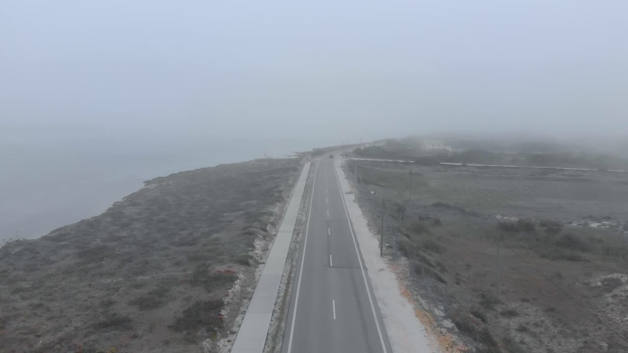 양쪽에 모래, 물, 덤불이 있는 자연 보호 구역의 도로 조감도