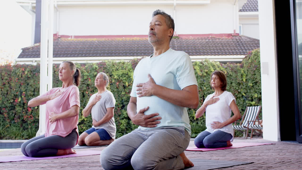 Practicing yoga, senior friends meditating on mats in outdoor session