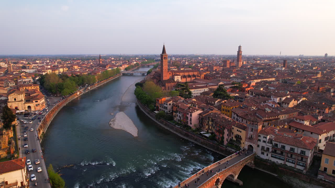 Aerial dolly out revealing Ponte di Pietra over the Adige river at sunset in Verona