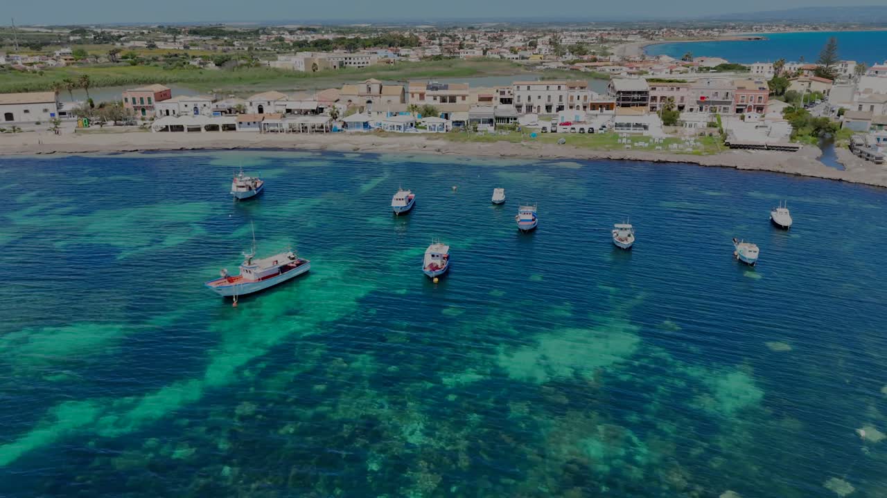 A drone flight horizontally in front of Marzamemi fishermen village revealing the beautiful landscape