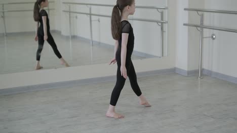 young ballerina practicing dance moves in studio