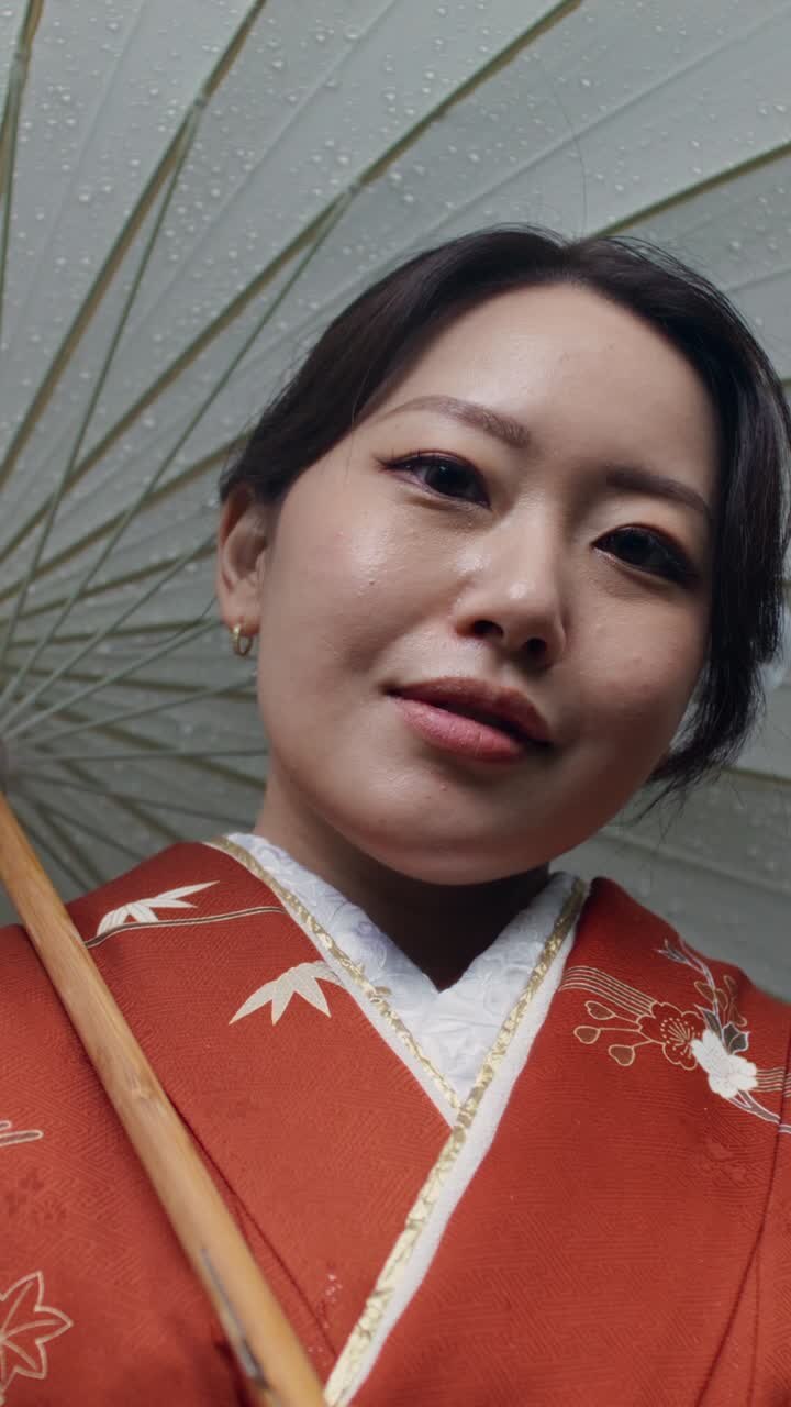 Donna in kimono sotto un ombrello