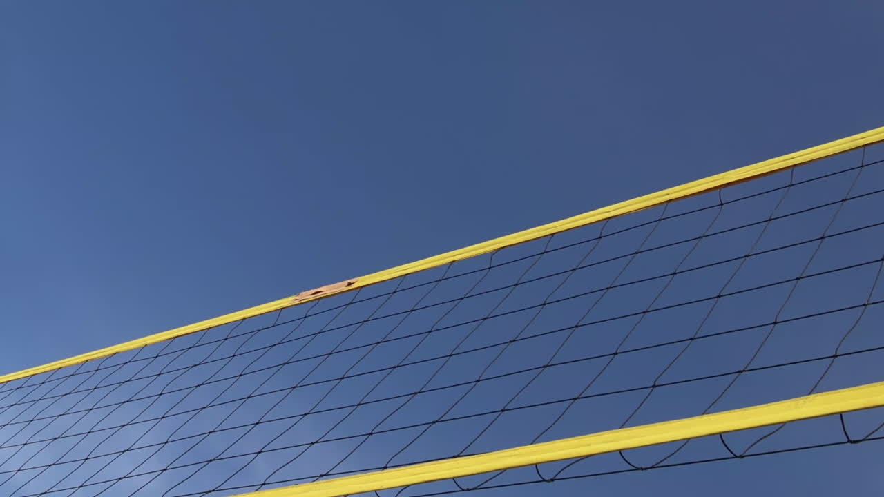 비치발리볼 네트 위로 공을 치는 손.