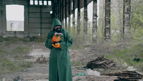 man in protective uniform and gas mask. post apocalyptic character with a gun standing in abandoned hangar