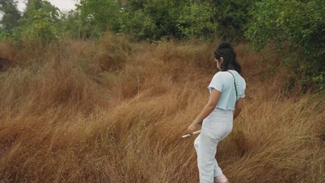 Young-girl-walking-through-dried-grass
