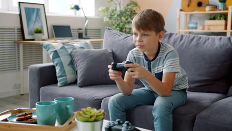boy playing video games on couch