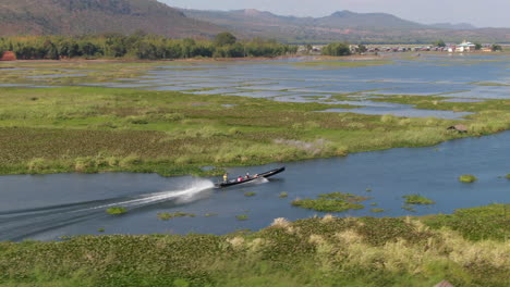 Traditional-long-boat-cruises-on-a-shallow-channel-near-Inle-Lame-in-Myanmar