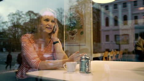 mujer hablando por teléfono móvil en un café