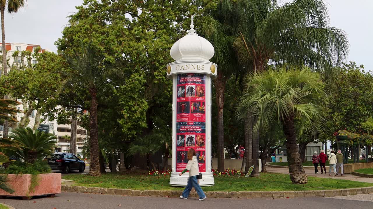 Cannes advertising column surrounded by lush greenery in public park