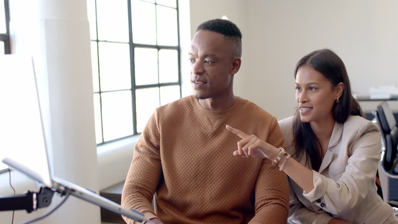 Discussing project, business colleagues collaborating and pointing at computer screen