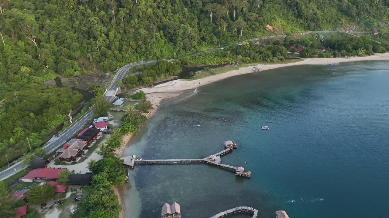 Drone aerial view of indonesian coastline padang west sumatra tropical ocean rainforest jungle trees small fishing village jetty