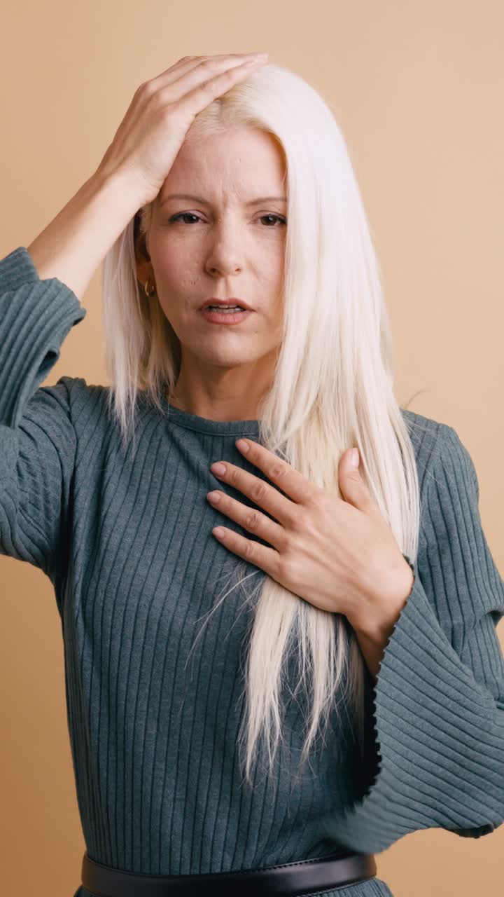 Kvinne med hodepine og stress holder seg til hodet