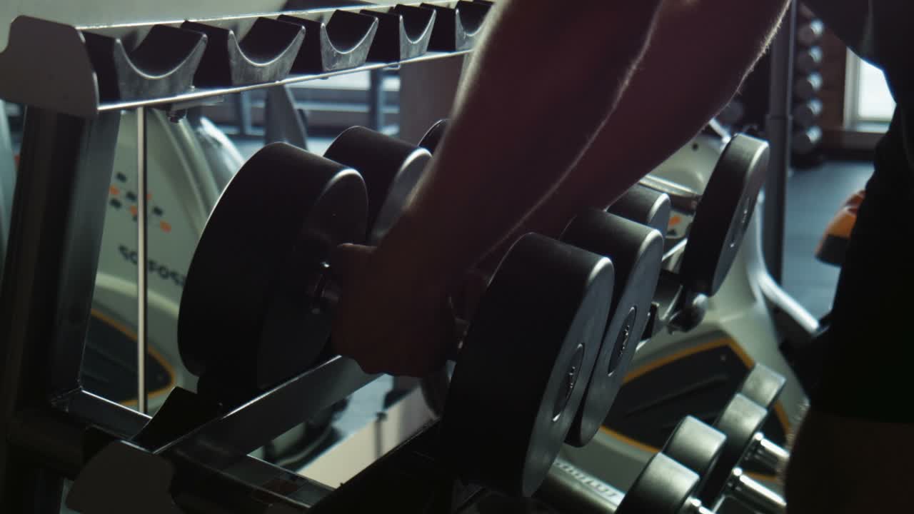 체육관 에서 덤벨 을 들어 올리는 사람