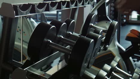 man lifting dumbbells in a gym