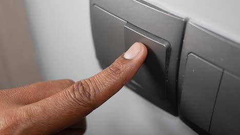 close-up of a finger pressing a light switch