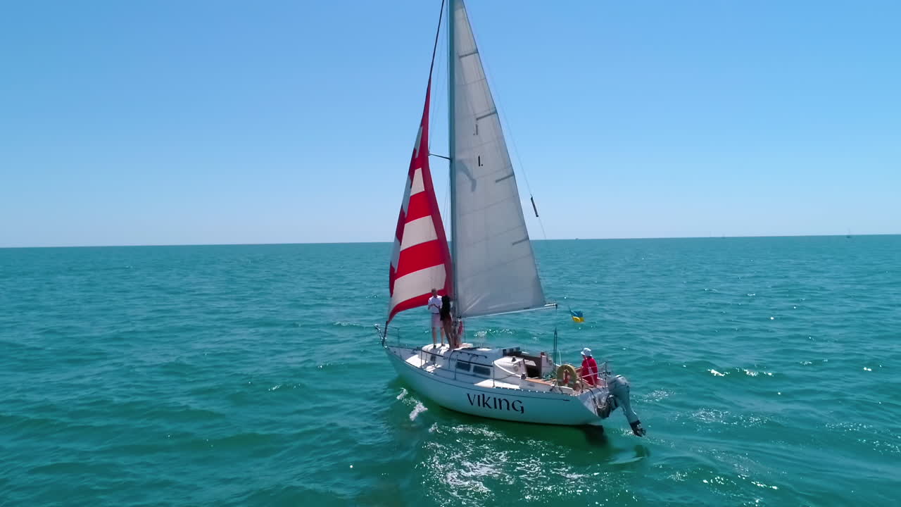 Sailing on sailboats at sea bay. White sailing ship on water at cinematic drone shot