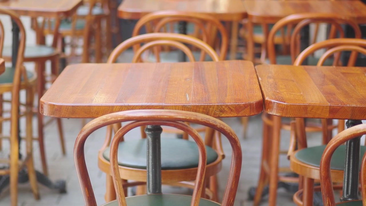 Tavoli e sedie di legno vuoti in un caffè all'aperto