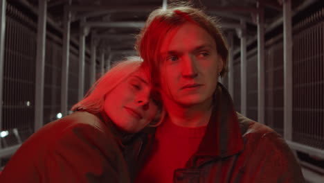 romantic couple standing on pedestrian bridge in night