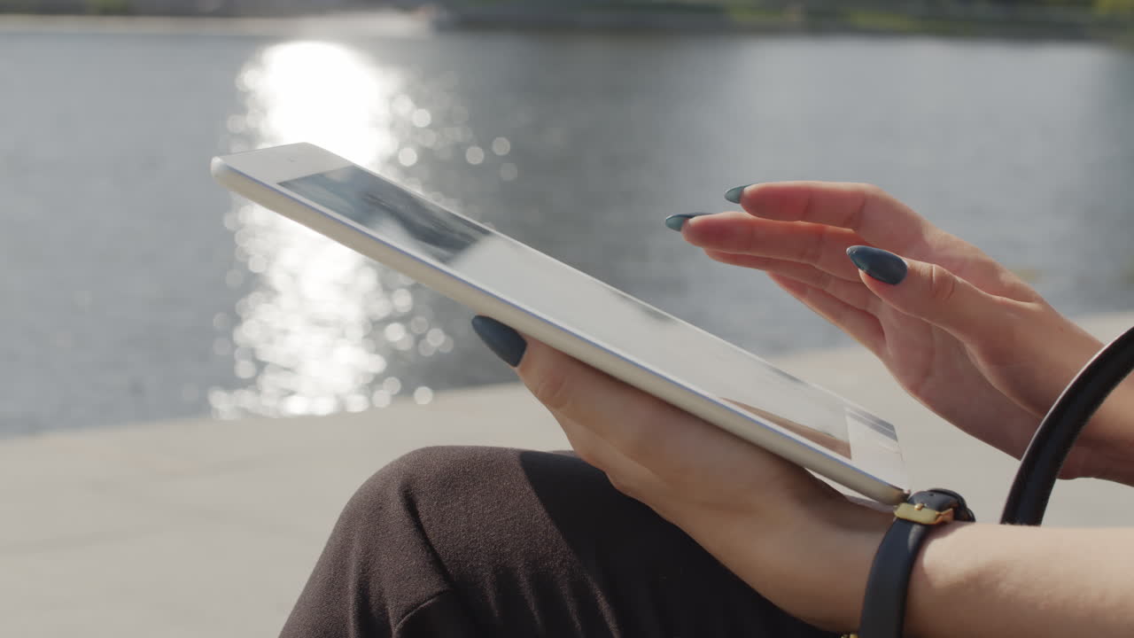 Woman Working On Digital Tablet Outside By River