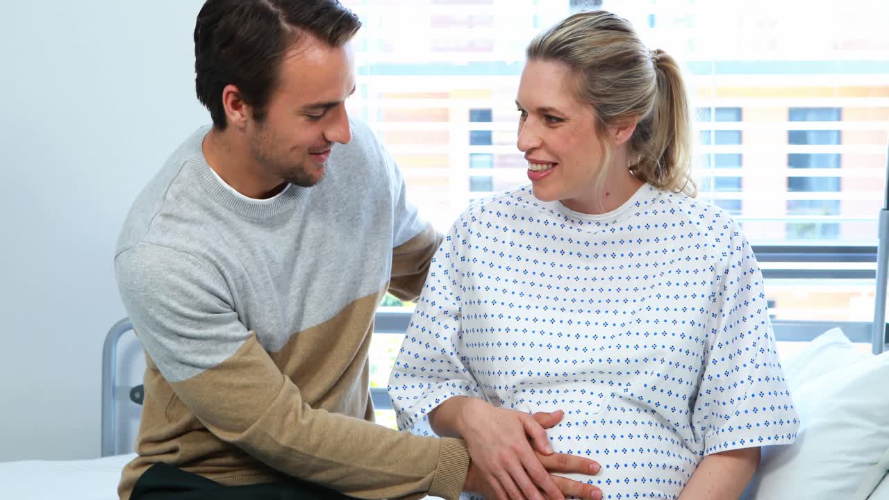 Man interacting with pregnant woman in ward
