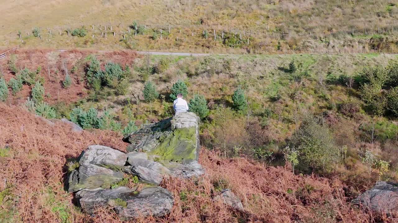 큰 바위 위에 앉아 있는 작은 소년, 생각에 몰입