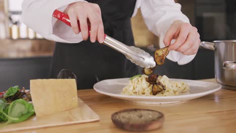 chef adding vegetables on pasta