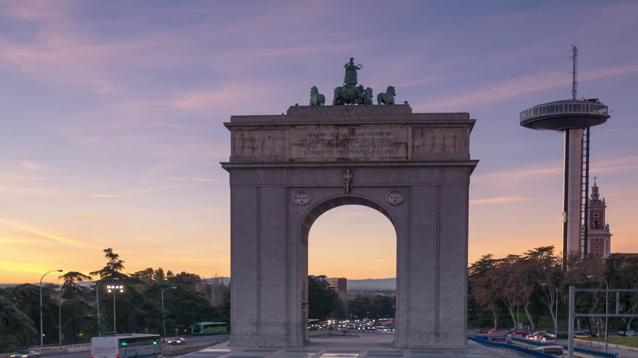 puesta de sol frente al arco de moncloa y faro de moncloa