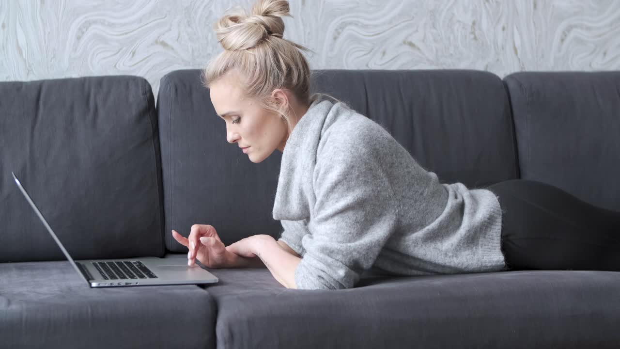 Happy Blond Woman Lying Prone On Sofa And Working On Laptop Computer Free  Stock Video Footage Download Clips Technology