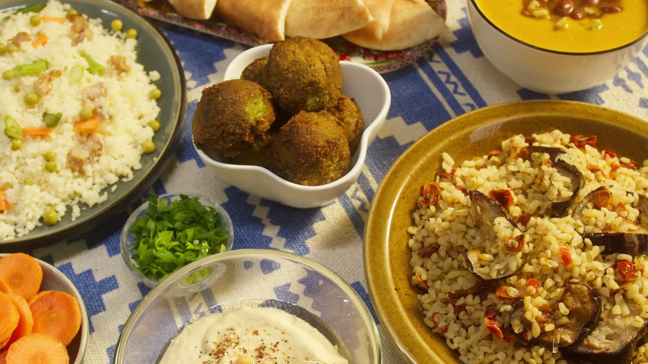 cocina árabe. bulgur con berenjena, falafel, sopa de frijoles en la mesa, cuscús con pollo. cultura tradicional de oriente medio. moutabal y ensalada de verduras en cuencos, pita. arroz delicioso con carne