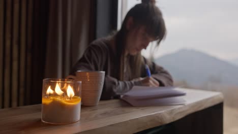 woman writing by candlelight